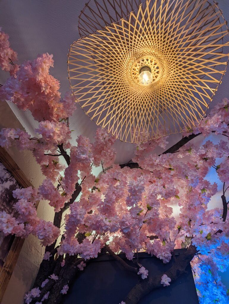 Holzlampe und Kirschblütenbaum im Restaurant Cơm Quê